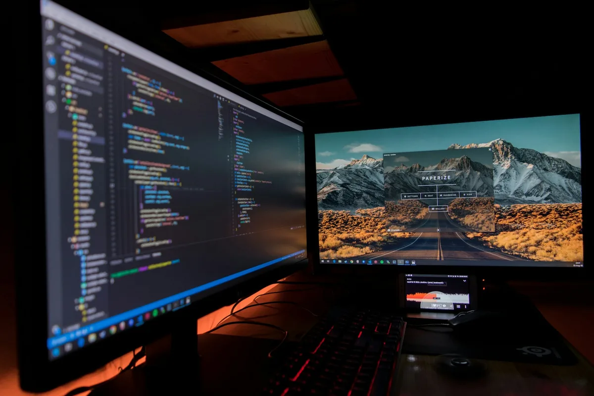 Two monitors side by side showing code