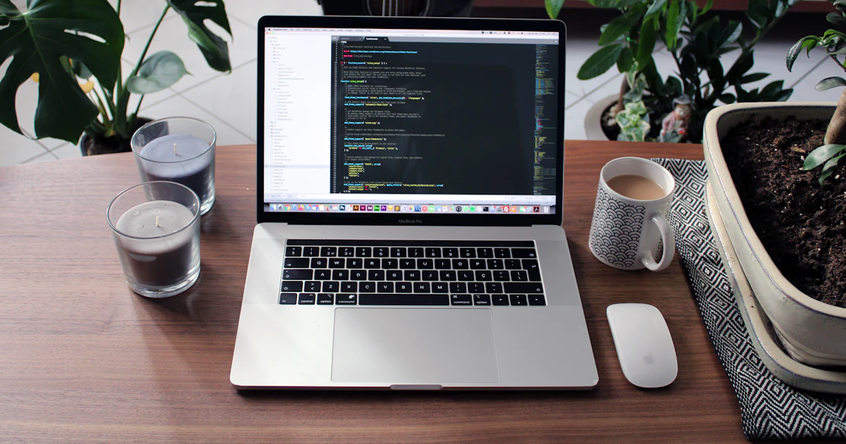 A laptop beside a mug on a wooden table