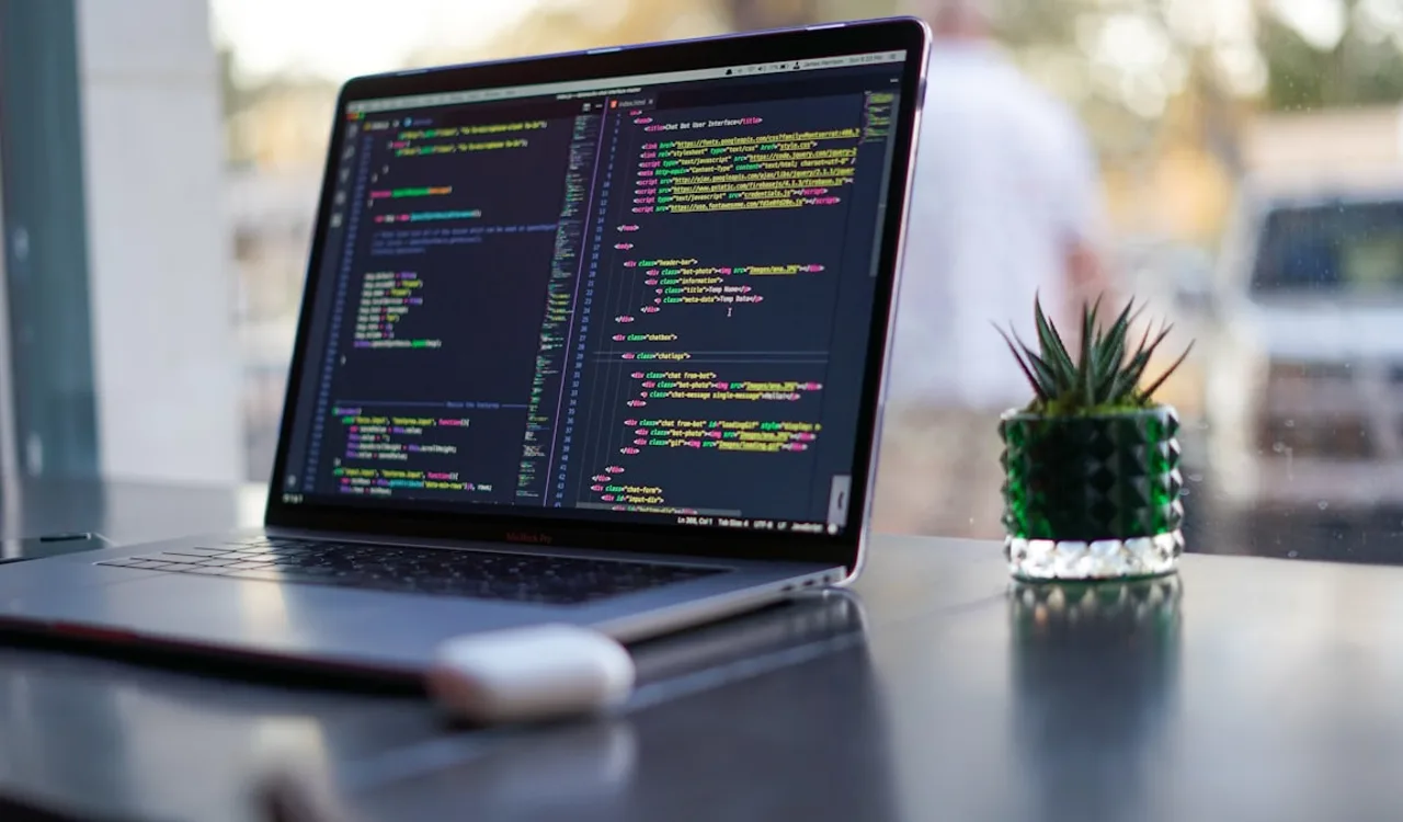 A developer writing TypeScript code with interfaces and class definitions visible on screen