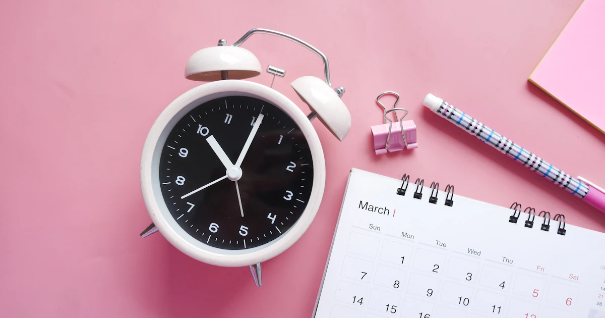 A white and pink analog alarm clock