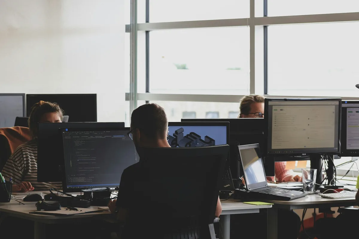 Team working at a shared bank of monitors