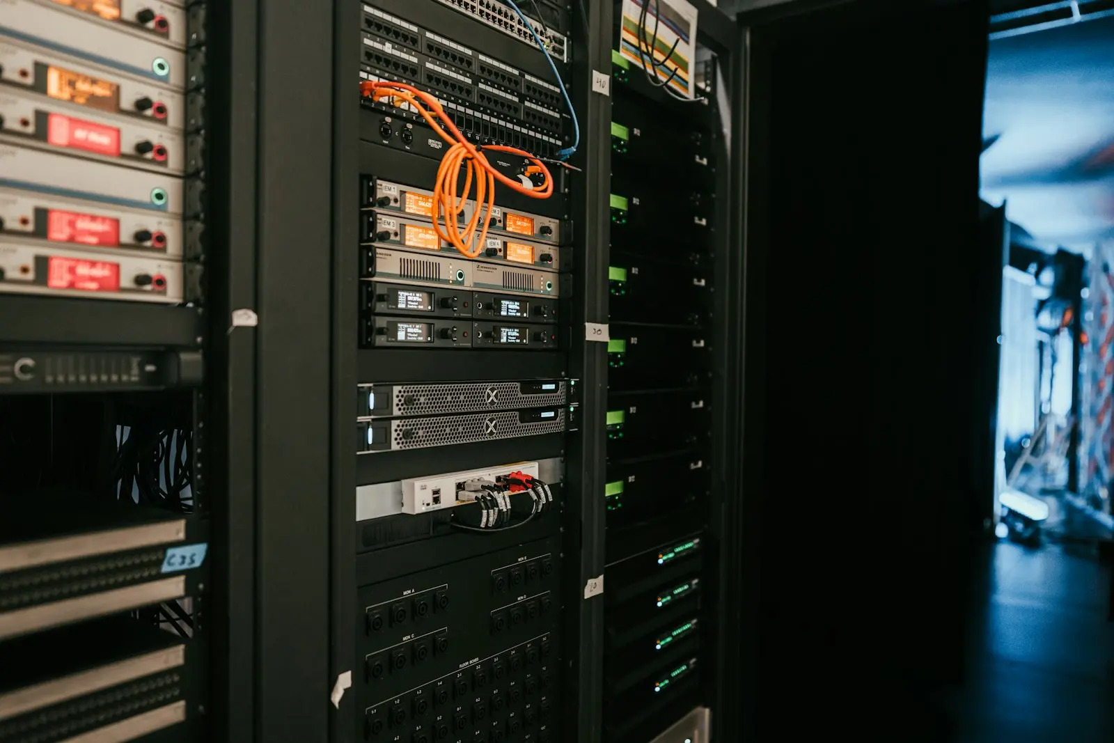 A row of server racks in a dim server room