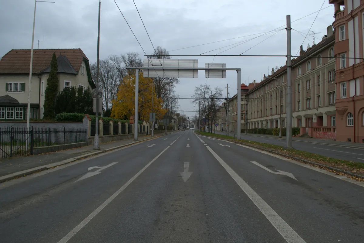 Empty city street with painted lane arrows and a gantry over the road