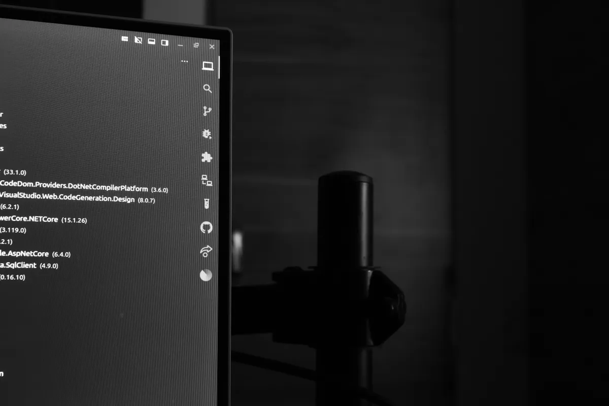 Monitor showing source code in a darkened room