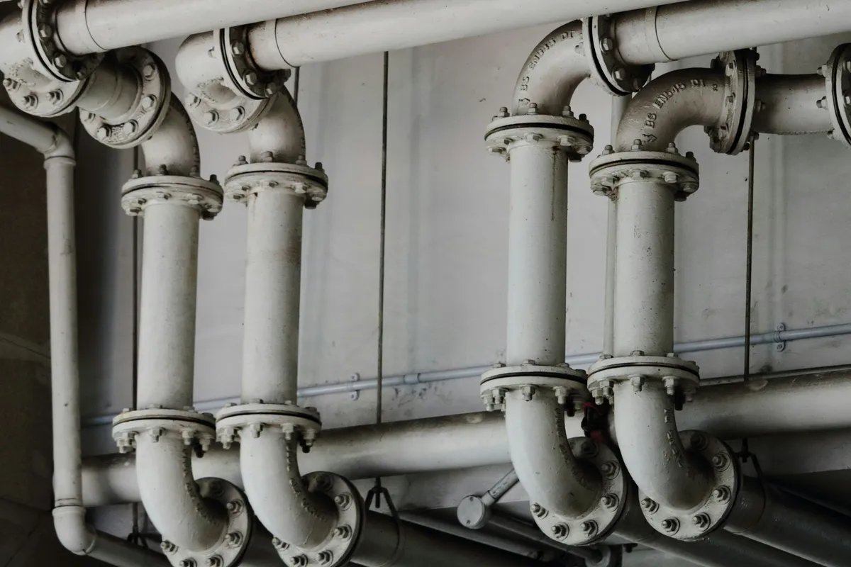 Parallel metal pipes running the length of a plant ceiling