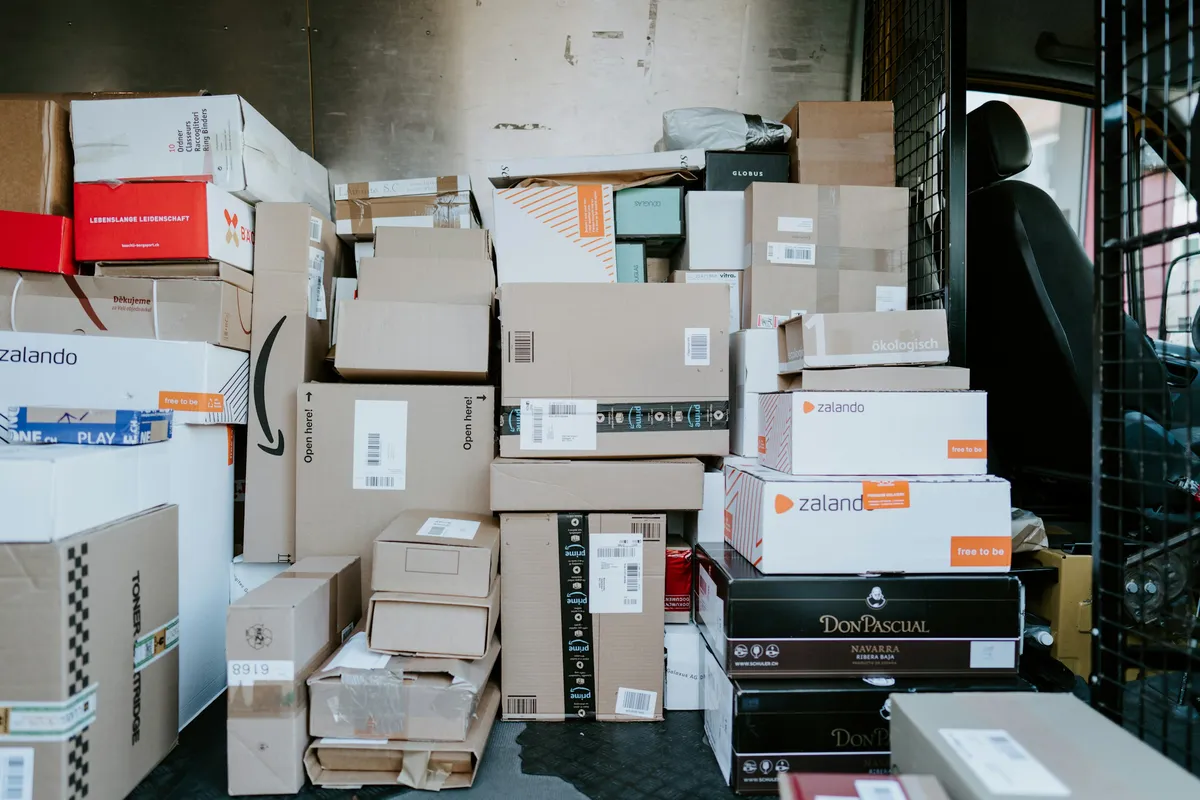 Stack of cardboard shipping boxes loaded inside the back of a delivery van