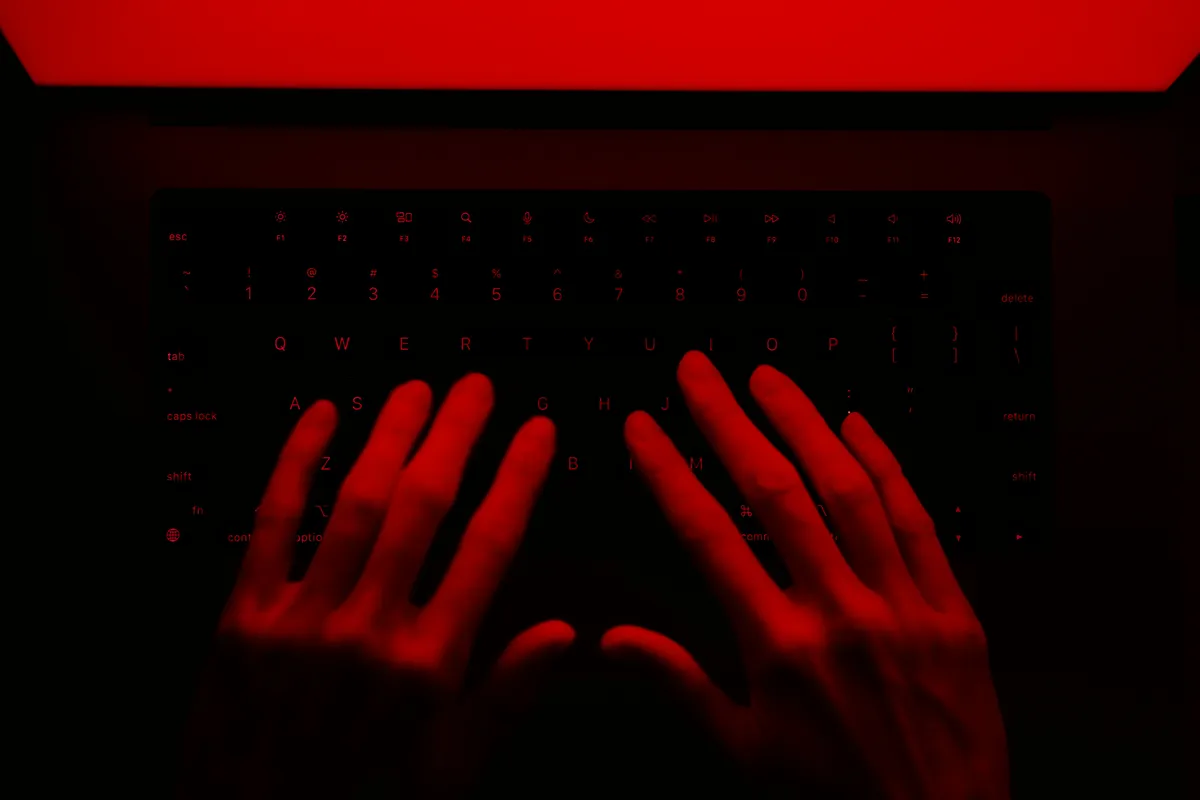 Hands typing on a keyboard lit in red, evoking a late-night migration debugging session