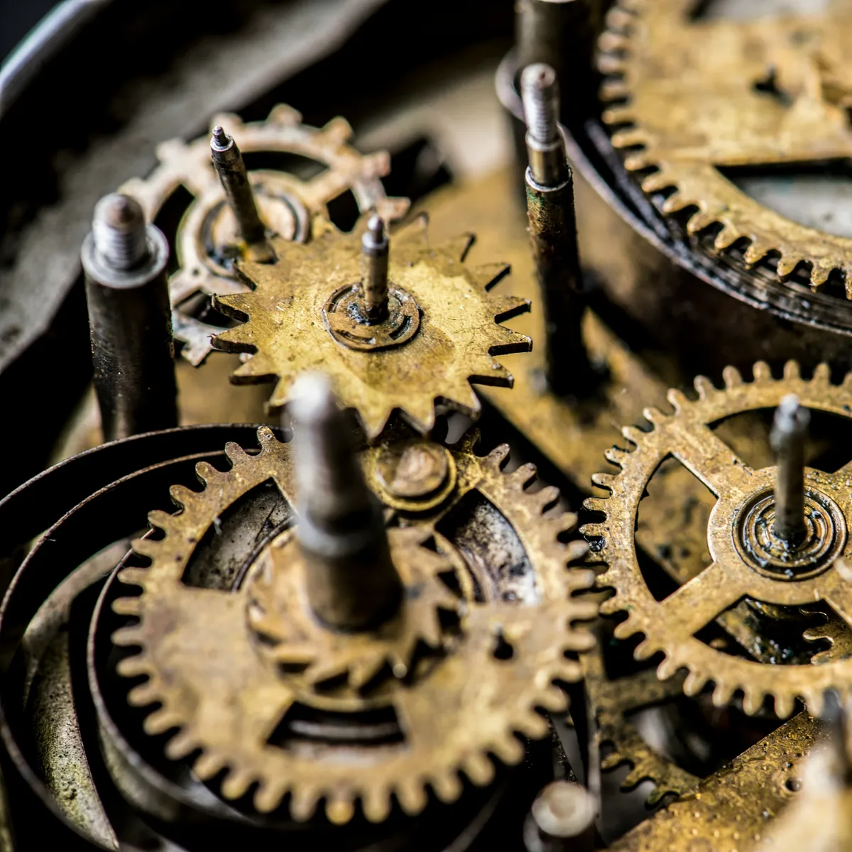 Close-up of interlocking brass clockwork gears turning together