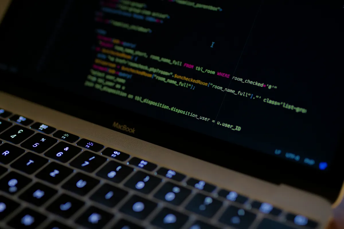 Close-up of a laptop screen displaying colorful lines of source code