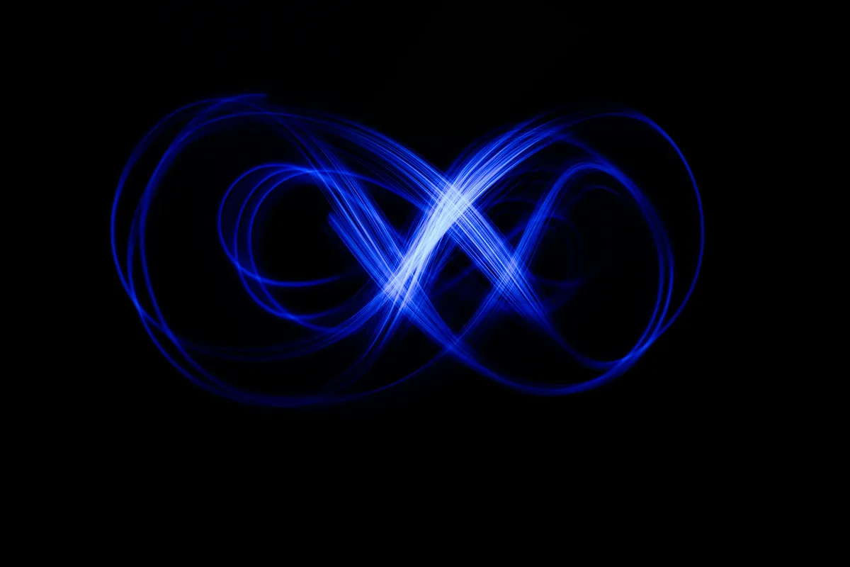 Glowing blue light trails forming an infinite loop shape against a black background