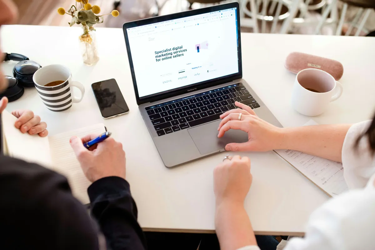 Person working through a form on a laptop at a bright desk