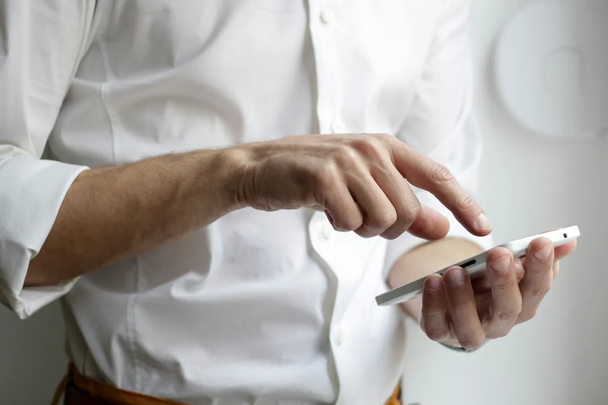 A thumb scrolling on a smartphone screen held in one hand