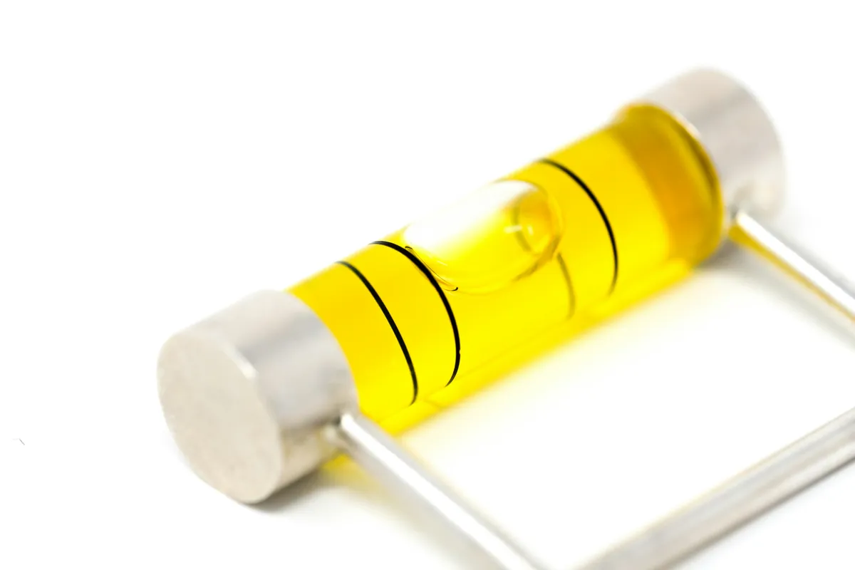Close-up of a yellow spirit level vial with a single air bubble between two marked lines
